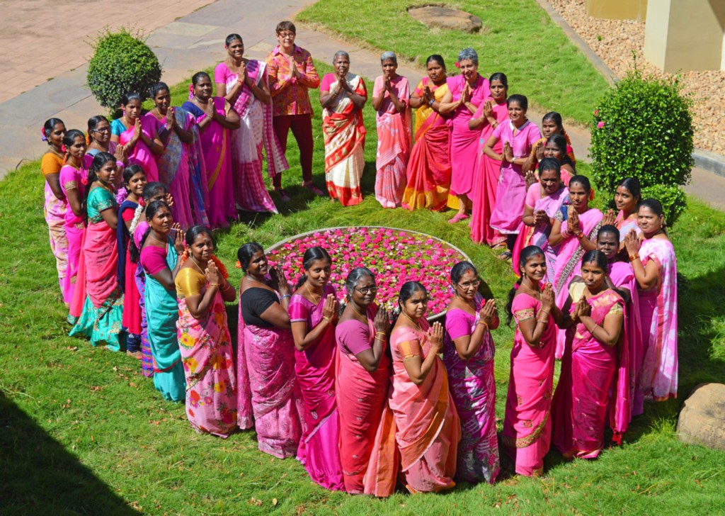 Maroma team gathered in a heart formation on the lawn at Auroville